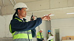 Woman, radio and talking on construction site for planning, project management and building regulation. Team supervisor, tech and point at worksite for renovation instruction for remodeling process