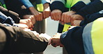 People, construction and meeting with fist bump in huddle for teamwork, unity or solidarity on site. Group, hands or contractor with circle, trust or support for community mission or building project