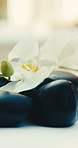 Spa, empty and towel with hot stones at resort for aromatherapy, skincare treatment and wellness. Pamper, background and flowers with heat therapy, holistic healing and stress relief for massage