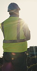 Construction, thinking and back of man in morning for planning, idea and building project. Architecture, flare and worker with decision for civil engineering, property development and crossed arms