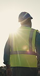 Construction, thinking and back of man in city for evaluation, planning and building project. Architecture, flare and worker with thought for remodeling, property development and ppe for engineering