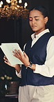Woman, concierge or checklist with tablet for reservation, hospitality or accommodation in hotel. Female person, receptionist or checking schedule with technology for online booking in luxury resort