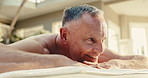 Spa, relax, and man on bed for massage with physical therapy, smile or luxury treatment at resort. Hotel, accommodation and mature person happy for stress relief, muscle reflexology or holistic detox