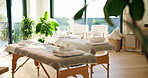 Interior, spa and bed for massage at resort, wellness retreat and atmosphere for body care. Background, setup and luxury holistic therapy with bodywork table, lodge or hotel with cosmetic service