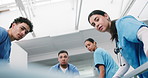 Gurney, patient and nurses push with emergency for healthcare transport or transfer in hallway. People, medical team or moving stretcher with face POV for clinic relocation, urgent care and low angle