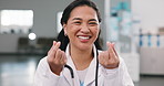 Face, woman and doctor with finger heart, kindness and appreciation gesture for medical support. Portrait, person or surgeon in hospital with love sign, thank you and gratitude for healthcare service