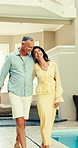 Happy, couple and travel with love in luxury resort for holiday, weekend or getaway by poolside. Mature, man and woman walking with smile in retreat for honeymoon trip, romantic date or vacation