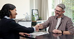 Meeting, handshake and happy man with insurance agent in office, conversation and signing paperwork. People, shaking hands and approval for policy in agency, consultation and smile for agreement
