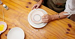Hands, person and painting in class with pottery, sculpture and custom design of handmade craft. Above, woman and paint brush in workshop with ceramic bowl, artistic process and diy creation for art