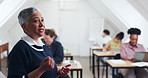 Woman, teacher and talking in class with students, learning and university lecture for knowledge. Mature person, professor and people at campus for discussion, academic course and education guidance