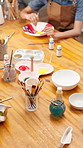 Hands, person and painting in workshop for pottery, sculpture and custom design of handmade craft. Potter, paint brush and decoration in class with clay bowl, artistic process and porcelain creation