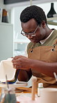 Smile, black man and painting in class for pottery, course and custom design of handmade craft. Potter, paint brush and decoration in workshop with clay bowl, artistic process and porcelain creation