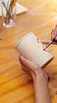 Hands, person and painting for pottery with clay, sculpture and custom design of handmade craft. Potter, paint brush and decoration in class with ceramic cup, artistic process and porcelain creation