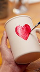 Hands, person and painting for pottery with sketch, sculpture and custom design of handmade craft. Potter, paint brush or decoration in class with ceramic cup, artistic process and porcelain creation