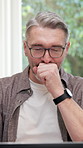 Man, yawning and remote work with laptop in house, tired and typing article for publication on web. Freelance, writer and mature person with glasses, exhausted and editing story with tech in home
