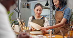 Pottery, instructor and women in class with advice, design idea guidance and painting technique. Happy potter, talk and teaching in studio for ceramics workshop, creative tips or feedback on artwork