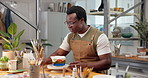 Pottery, black man and painting ceramic in workshop for merchandise, creative and small business. Happy person, pride and handmade craft store for manufacturing, productivity or artist thinking