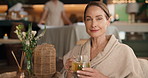 Face, tea and mature woman in spa for beauty treatment, wellness and salon service in luxury resort. Portrait, drink and person with robe for holistic healing, therapy and stress relief at retreat