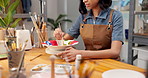 Pottery, hands and painting ceramic in shop for merchandise, creative and small business or startup. Female person, workshop and handmade craft store for manufacturing, productivity or artist brush
