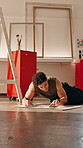 Artist, man and drawing in art studio with phone, planning and search online reference for project. Creative, person and sketch on floor with tech, illustration or check social media for inspiration.