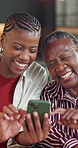 Smile, black family and old woman at house with phone, social media and reminiscing for bonding. Senior parent, adult daughter or laugh in home with mobile, browsing website and funny video in lounge