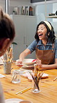 Woman, laugh and painting in art class with ceramics, funny discussion and friends bonding together. Happy, person and creativity in workshop with paintbrush, clay product and joke for conversation.