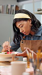 Creative, woman and painting pottery in workshop for art merchandise, productivity or handmade craft. Paintbrush, person and potter with ceramic in studio for artistic manufacturing in small business