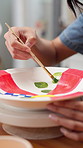 Hands, woman and painting pottery in class for art, creative decoration hobby and handmade craft. Paintbrush, person and ceramic in studio for custom design, artistic process and pattern inspiration