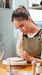 Creative, woman and painting ceramic in workshop for art merchandise, productivity or handmade craft. Paintbrush, person and potter with pottery in studio for artistic manufacturing in small business