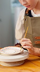 Hand, woman and painting ceramic for art in workshop, creative decoration or handmade craft. Paintbrush, person or pottery in studio for skill development, artistic process and hobby with design