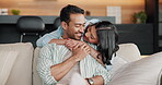 Love, couple and hug with talk on sofa for bonding together, healthy relationship and security. Care, happy people and embrace in home for affection, marriage loyalty or conversation on weekend break