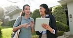 Realtor, client and discussion by home with tablet, property viewing and explain HOA policy outdoor. Real estate agent, women and talk in front yard with tech, house hunting or research neighborhood.