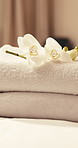 Hotel, bed and towel at spa with flower, guest arrival and welcome experience for hospitality. Empty, bedroom or fresh linen at resort with floral decor, complimentary service and luxury housekeeping