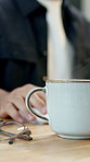 Businessman, hands and coffee with cup in office for online report, caffeine or productivity. Man, employee or journalist typing with mug, tea or warm beverage for energy, interesting story or news