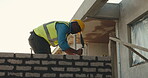 Brick wall, building and civil engineering with black man in neighborhood for property development. Construction, home and process with builder on worksite for addition, improvement or security