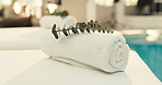 Towel, plant and spa with massage table in luxury resort for zen, accommodation or holiday getaway. Empty, leaves and fabric with cloth by poolside for hospitality, therapy or vacation in salon