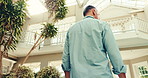 Back, man and walk at holiday house for weekend break, luxury retirement or travel adventure. Low angle, mature person or relax at lodge for vacation getaway, resort accommodation and hospitality