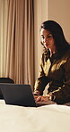 Remote work, typing and woman with laptop in hotel, online or research for story development on web. Travel, writer and happy mature person with technology, freelancer and editing article in bedroom