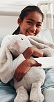 Face, child and hug stuffed animal in hospital bed with smile, comfort and optimistic for recovery. Happy, girl and embrace plush toy in pediatric clinic with good mood, rest or healing from disease.