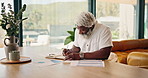 Mature, writing and black man with documents in home for investment statistics, profit or revenue. Male person, analysis or remote work with paperwork for analytics, budget planning or house expenses