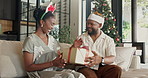Christmas, present and happy black couple together on home sofa for bonding, quality time and love. Man, woman or festive season in house with hug, xmas gift and surprise for holiday celebration