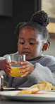 Child, glass and juice at house for breakfast, fresh fruit and vitamin c for healthy lifestyle. Family, eating and kid in kitchen with beverage, citrus drink and homemade pancakes for morning brunch
