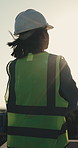 Construction, thinking and back of woman with helmet for planning, reflection and civil engineering. Architecture, city and worker with ppe for safety compliance, remodeling and property development