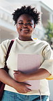 Face, student and happy woman in college with book, scholarship opportunity and future for education. Black person, outdoor and learning resources in university with smile, study grant and knowledge.