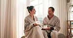 Couple, happy and talking with tea at spa, beverage or anniversary getaway for connection. Mature, man and woman with herbal drink, relationship milestone trip and communication for bonding at resort