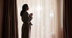 Thinking, coffee and woman by window at hotel for break on vacation, holiday and getaway in morning. Happy, reflection and person with drink, relax and view for accommodation, hospitality and travel