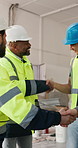 Construction, meeting and team with handshake for architecture deal, contract or project on site. People, electrician or builder shaking hands with architect for building plan, security or safety