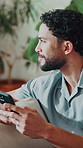 Thinking, phone and man in home with text message, online chat and notification on social media. Happy, typing and person in house with tech, communication app and post reflection on digital platform
