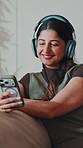 Headphones, happy and woman with phone on sofa for streaming song, audio and create playlist. House, relax and person with cellphone for radio, track and listening with music subscription on weekend