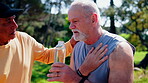 Fitness, support or old man with chest pain, water recovery or cardiac concern in park exercise. Wellness, help or senior team with bottle, breathing difficulty or heart condition in workout activity
